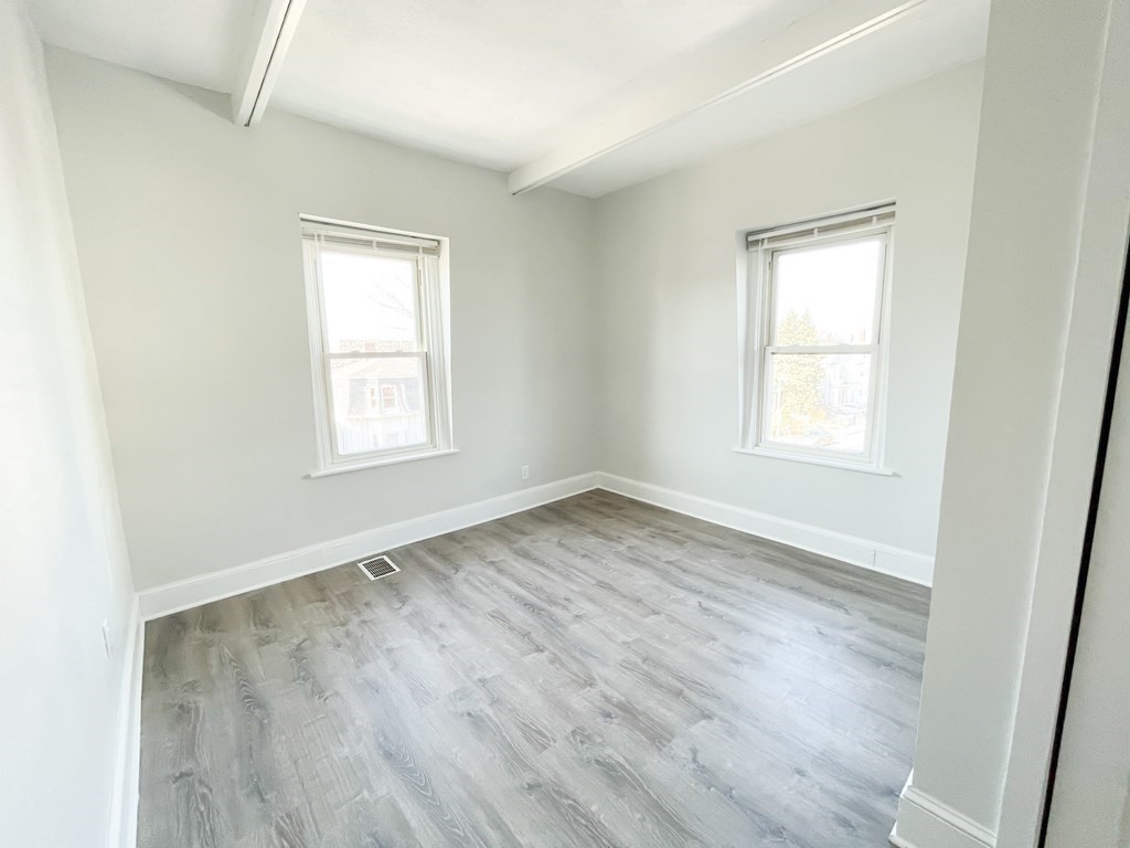 30 Woodbine Street Boston, MA 02119 - Photo 22 of 41 an empty room with wooden floor and windows