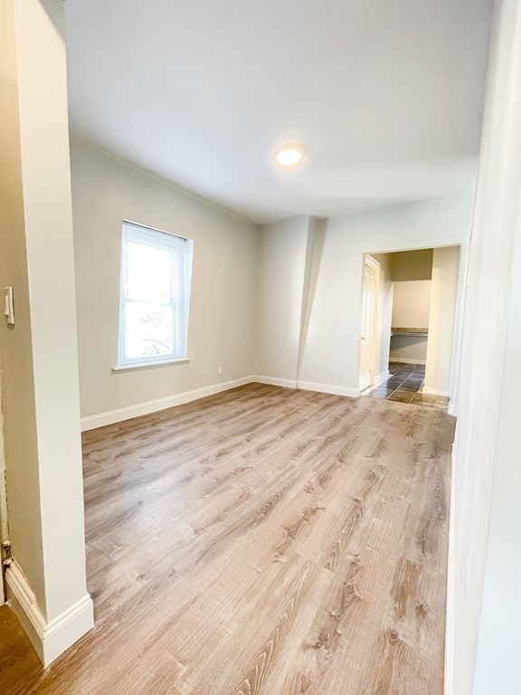 30 Woodbine Street Boston, MA 02119 - Photo 25 of 41 an empty room with wooden floor and windows