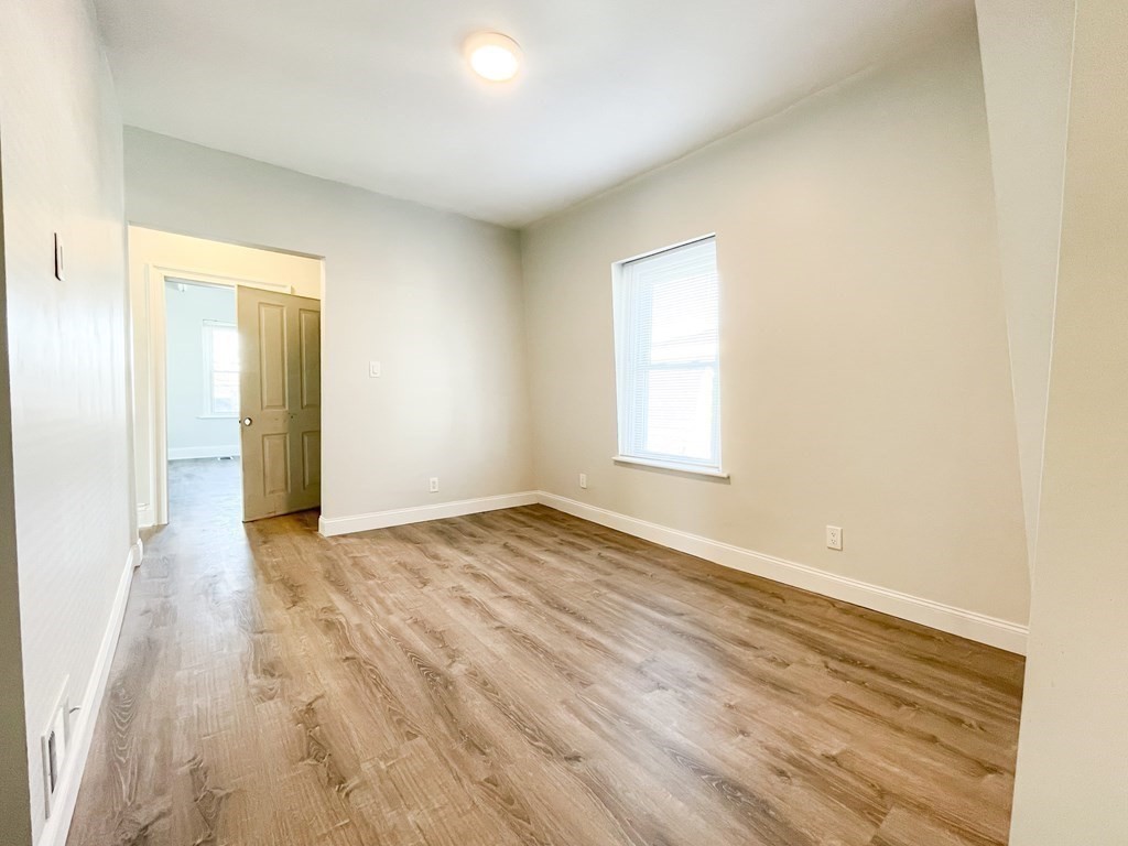 30 Woodbine Street Boston, MA 02119 - Photo 26 of 41 an empty room with wooden floor and windows