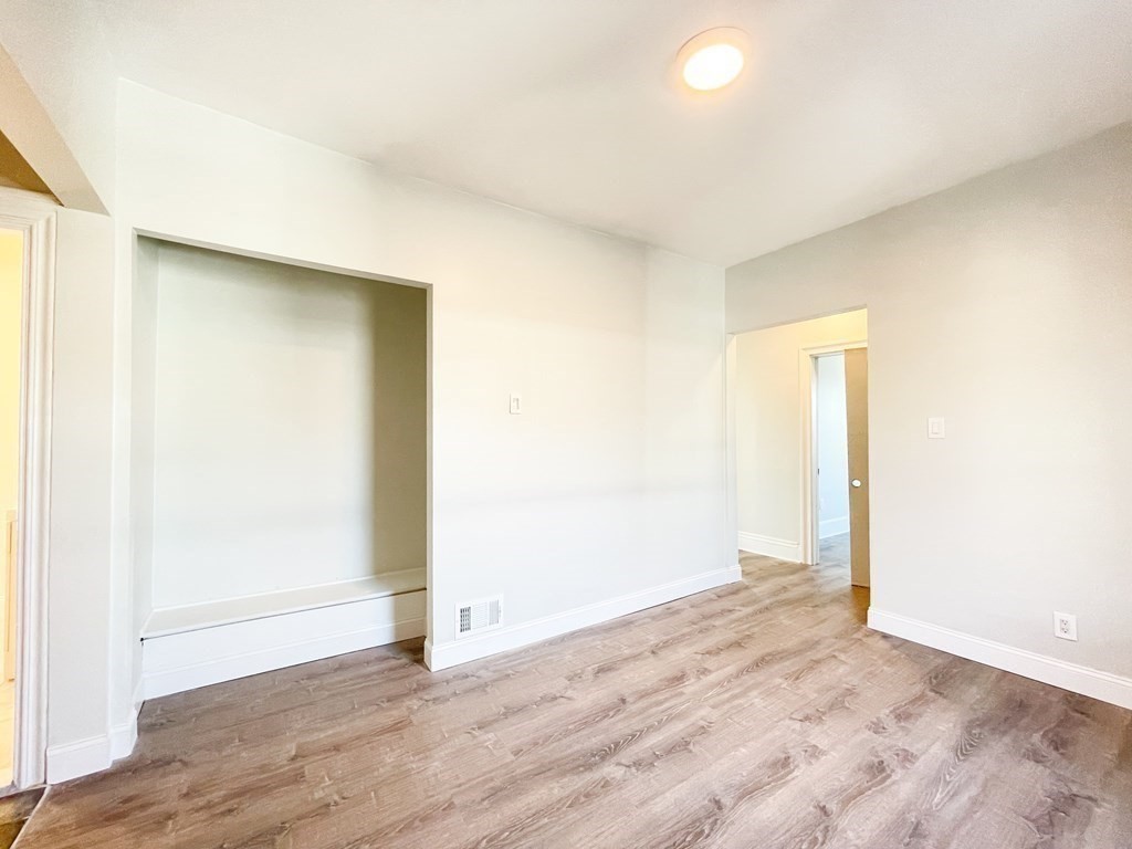 30 Woodbine Street Boston, MA 02119 - Photo 27 of 41 an empty room with wooden floor and windows