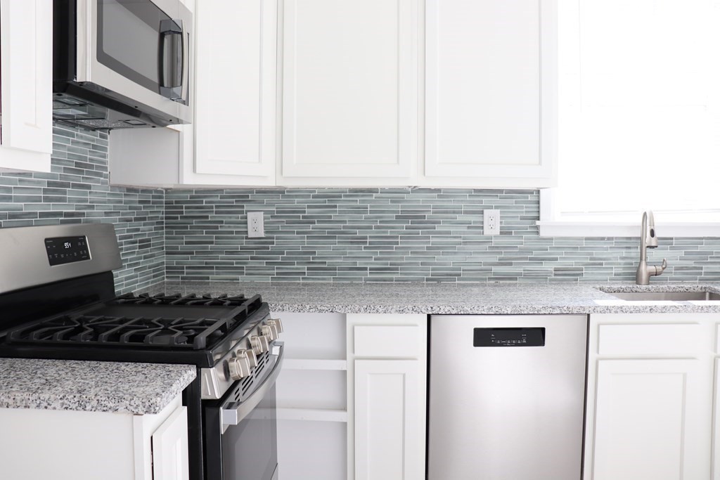 30 Woodbine Street Boston, MA 02119 - Photo 3 of 41 a kitchen with stainless steel appliances granite countertop a sink stove and cabinets
