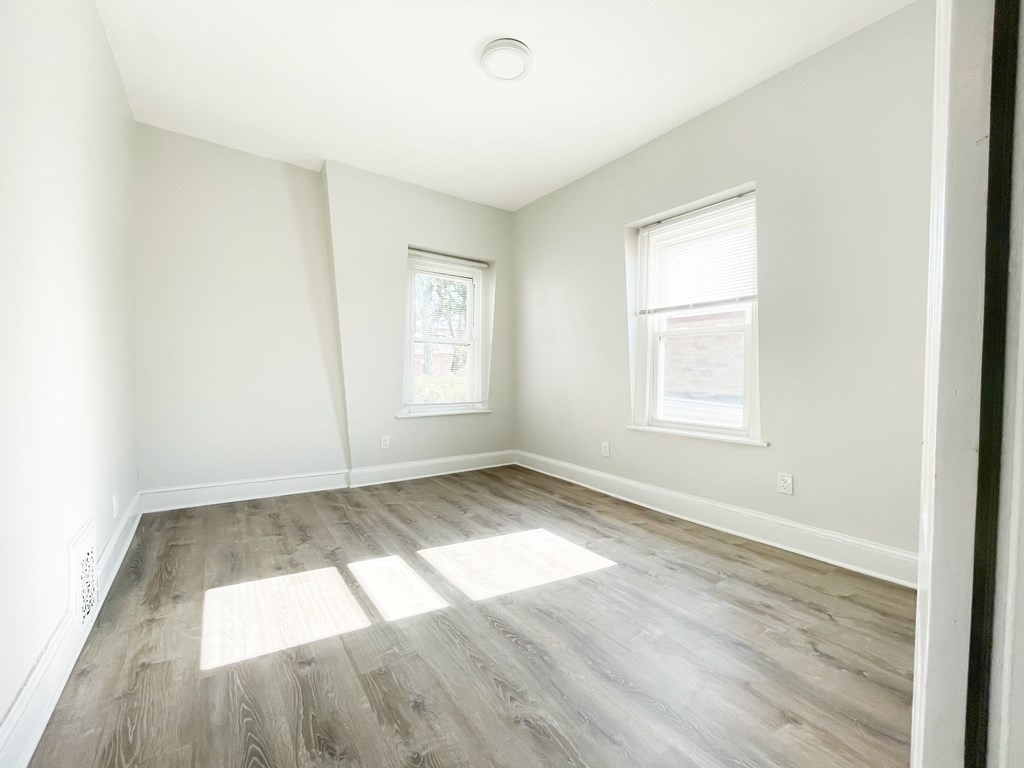 30 Woodbine Street Boston, MA 02119 - Photo 32 of 41 an empty room with wooden floor and windows