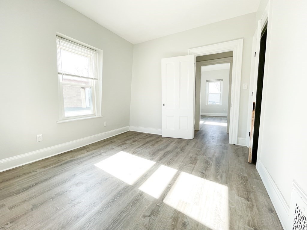 30 Woodbine Street Boston, MA 02119 - Photo 33 of 41 an empty room with wooden floor and windows