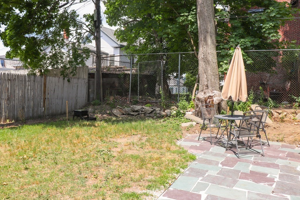 30 Woodbine Street Boston, MA 02119 - Photo 40 of 41 a backyard of a house with table and chairs