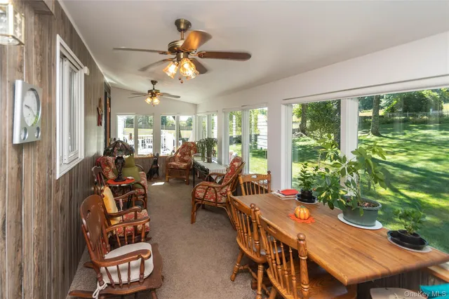 a room with lots of furniture a chandelier fan and a large window