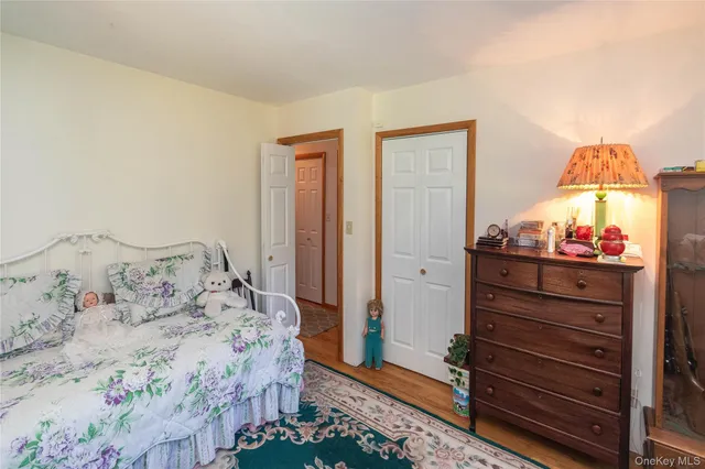 a bedroom with a bed and a lamp on dresser