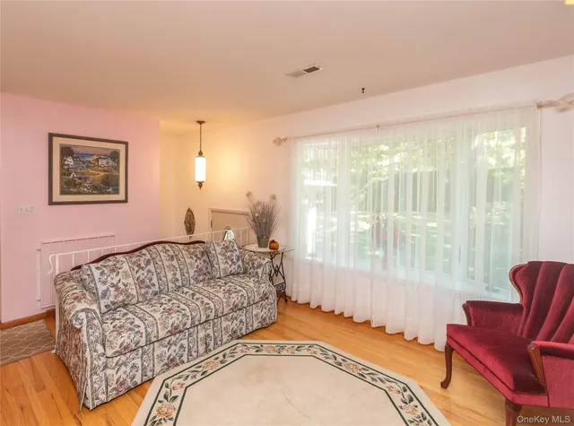 a living room with a bed furniture and a large window