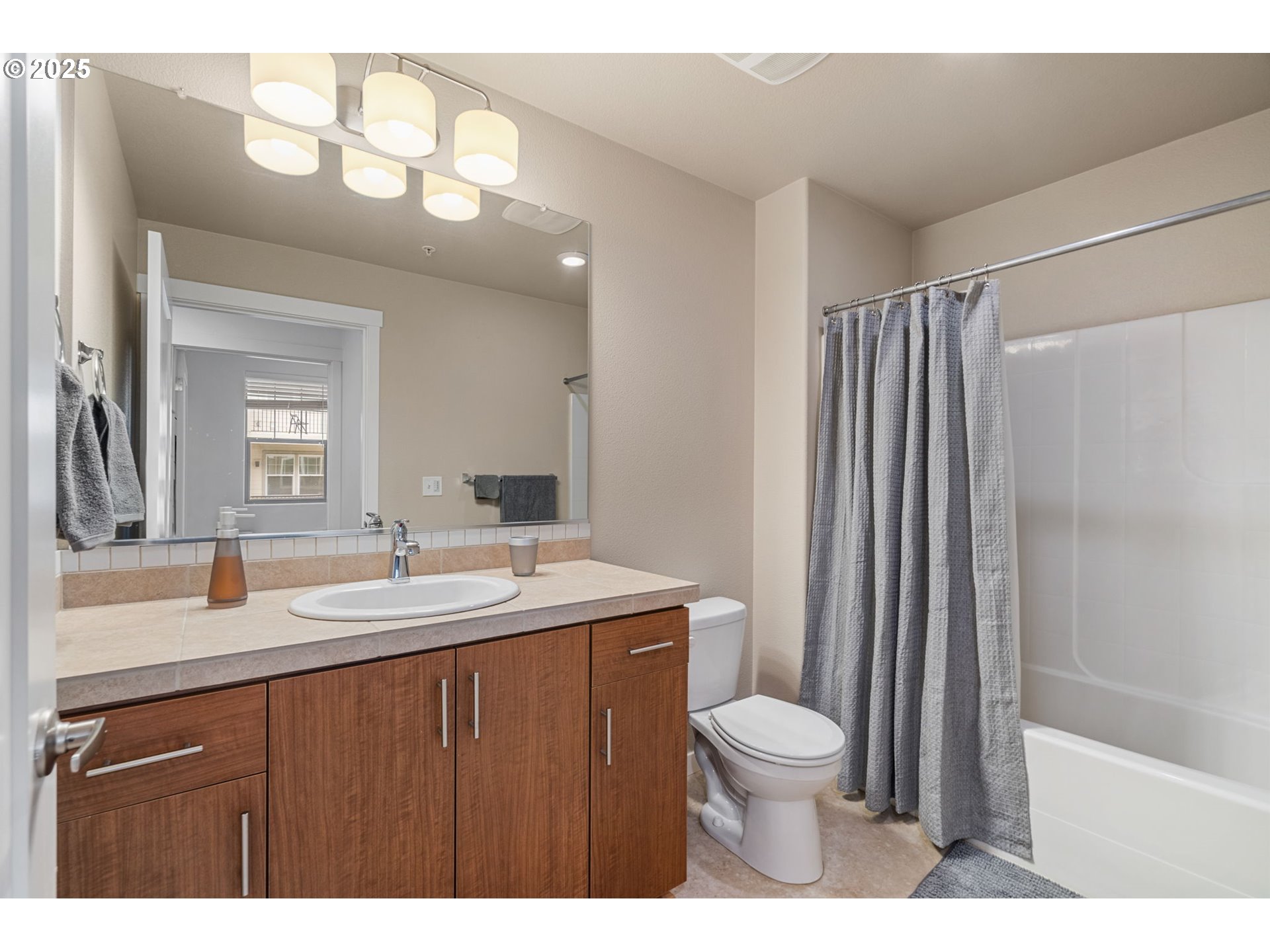 17181 Southwest Snowdale Street, Unit 204 Beaverton, OR 97007 - Photo 5 of 13 a bathroom with a granite countertop sink toilet a mirror a vanity and shower