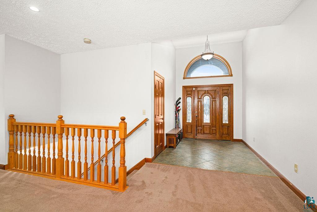 2542 Ziehl Road Carlton, MN 55718 - Photo 13 of 51 Entryway featuring carpet, a high textured ceiling, and tile patterned flooring