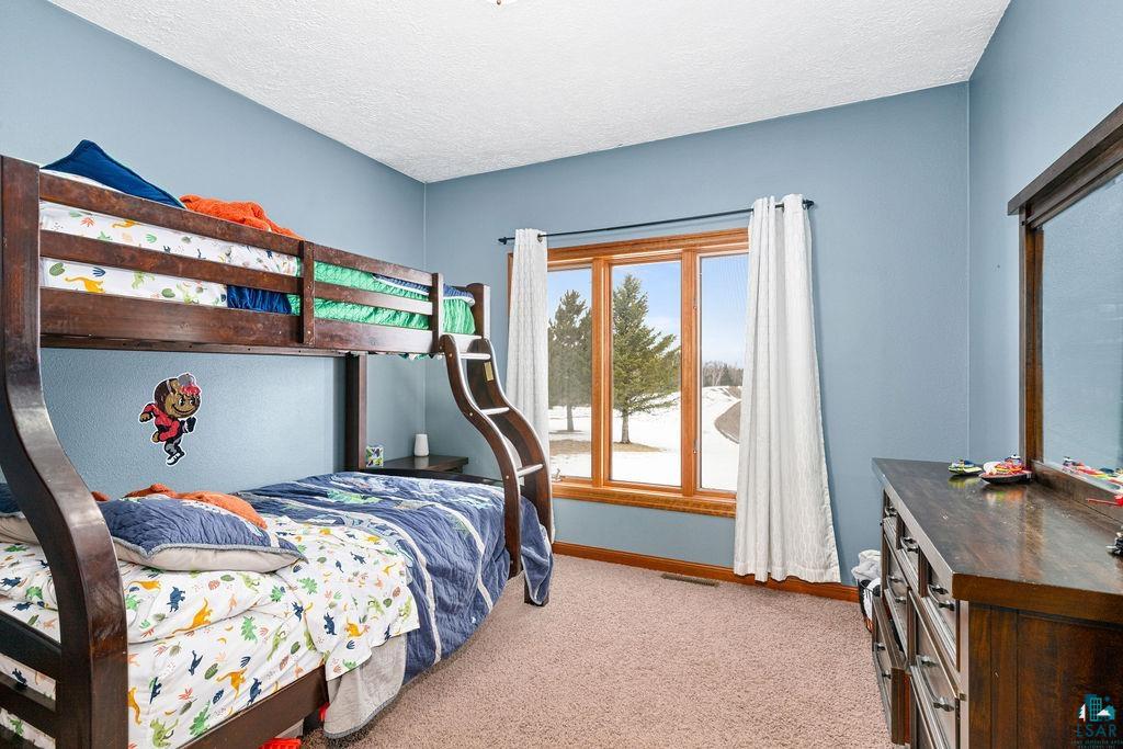 2542 Ziehl Road Carlton, MN 55718 - Photo 27 of 51 Bedroom featuring light colored carpet and a textured ceiling