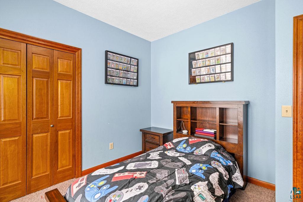 2542 Ziehl Road Carlton, MN 55718 - Photo 30 of 51 Bedroom with carpet, a closet, and a textured ceiling