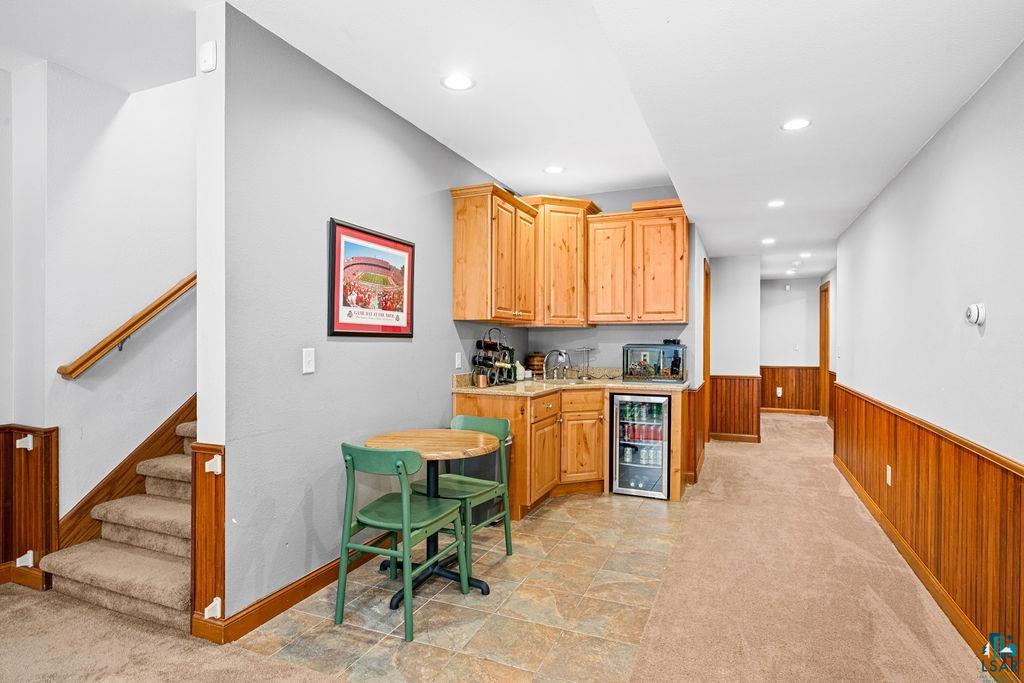 2542 Ziehl Road Carlton, MN 55718 - Photo 31 of 51 Kitchen featuring wood walls, beverage cooler, wainscoting, light carpet, and recessed lighting