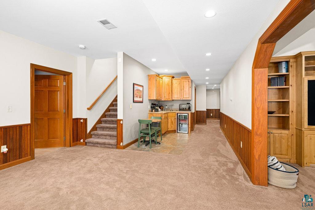 2542 Ziehl Road Carlton, MN 55718 - Photo 35 of 51 Home office featuring wooden walls, wainscoting, recessed lighting, beverage cooler, and light carpet