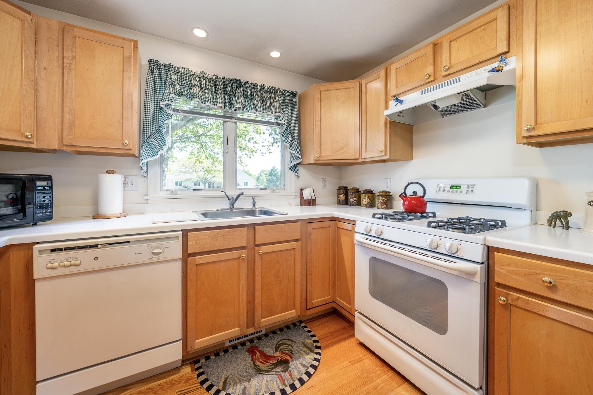 7 Masters Court Mashpee, MA 02649 - Photo 9 of 34 a kitchen with granite countertop white cabinets sink and white appliances