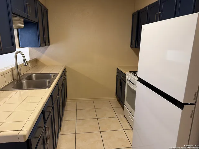 a kitchen with a sink stove and refrigerator