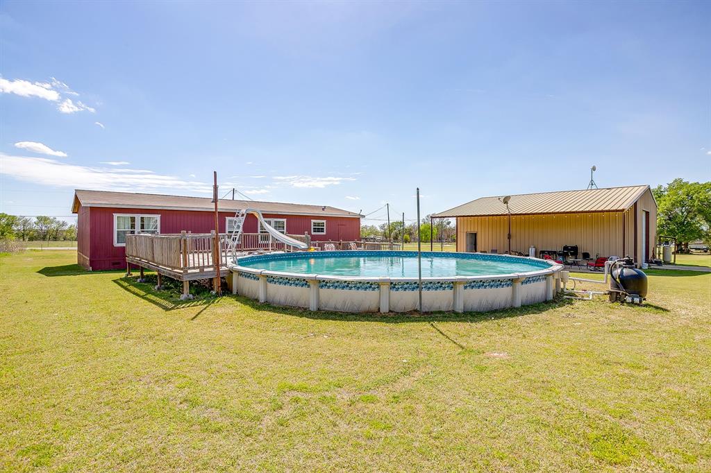 321 Young Road Millsap, TX 76066 - Photo 28 of 28 a view of a swimming pool with an outdoor seating and house in the background