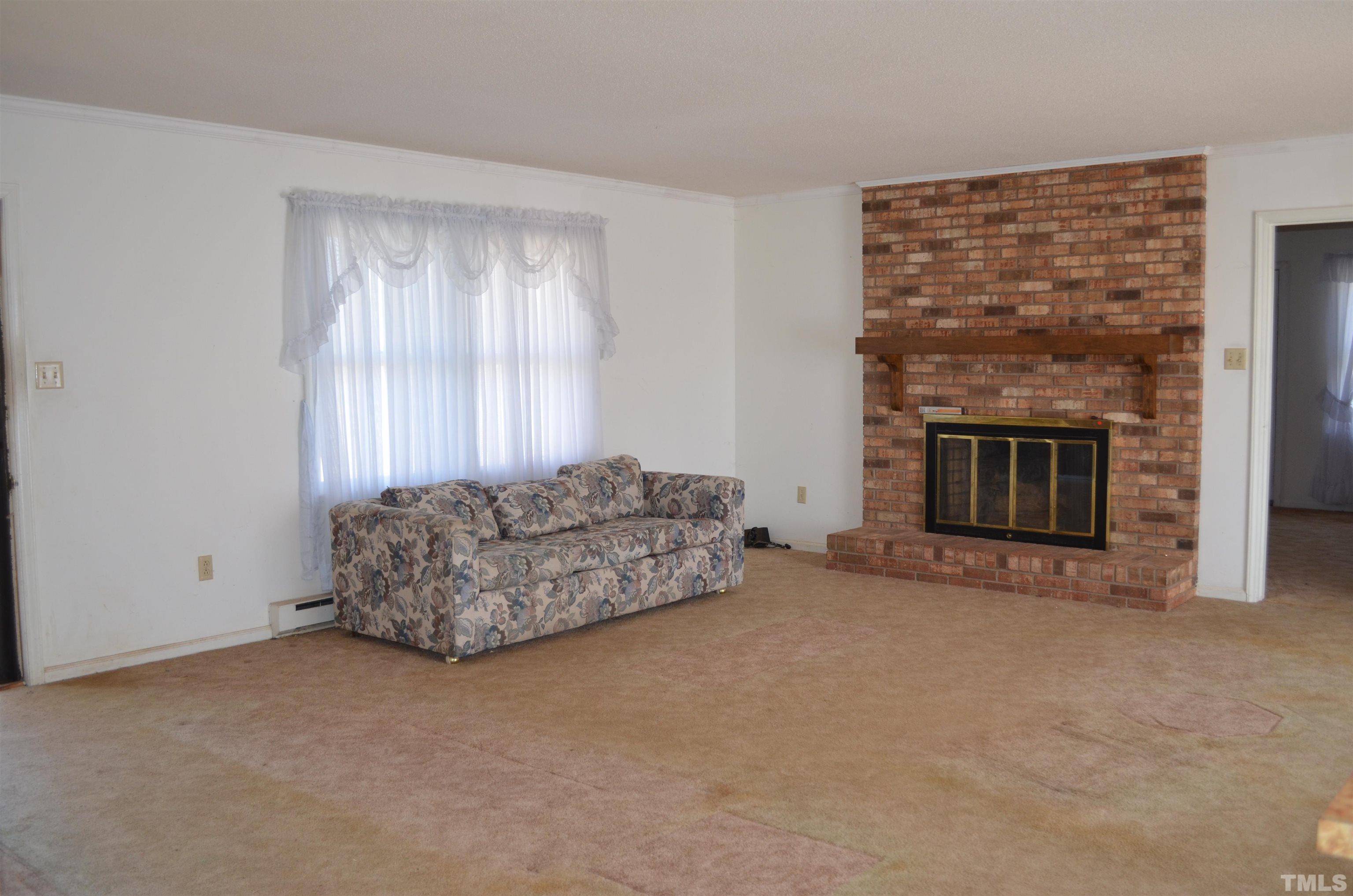 123 Joe Brown Road Bear Creek, NC 27207 - Photo 4 of 32 a living room with furniture and a fireplace