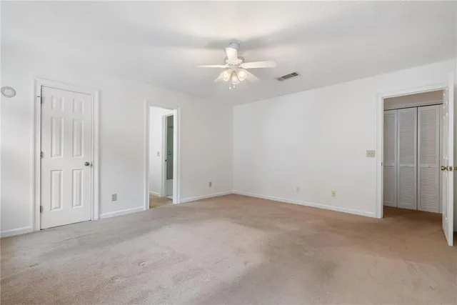 an empty room with fan and entryway