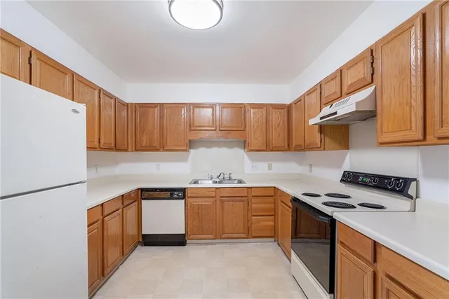 a kitchen with stainless steel appliances granite countertop a stove a sink dishwasher and a refrigerator