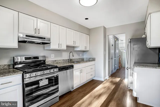 a kitchen with stainless steel appliances a stove sink and cabinets