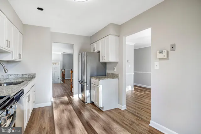 a kitchen with a refrigerator and a stove top oven