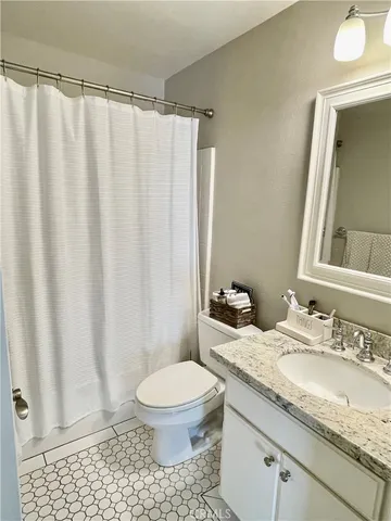 a bathroom with a granite countertop sink toilet and a mirror