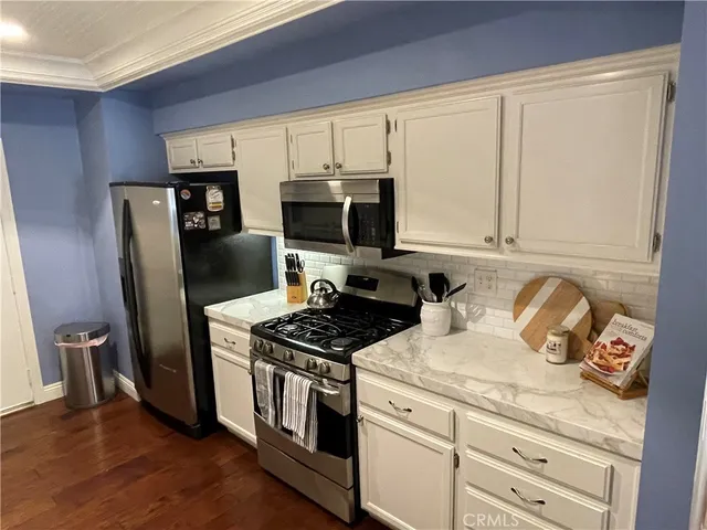 a kitchen with stainless steel appliances a stove microwave and refrigerator