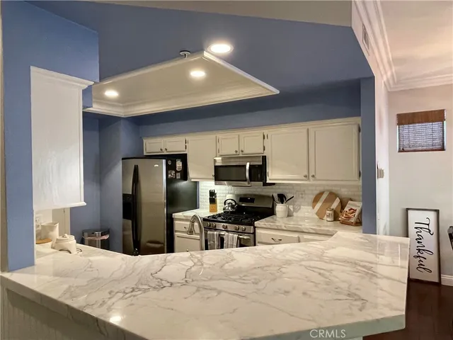 a kitchen with refrigerator a sink and a microwave