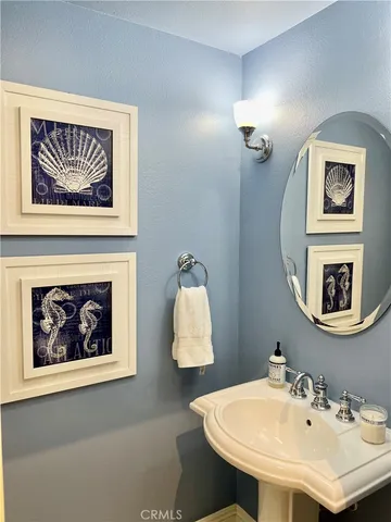 a bathroom with a sink a mirror and a painting on the wall