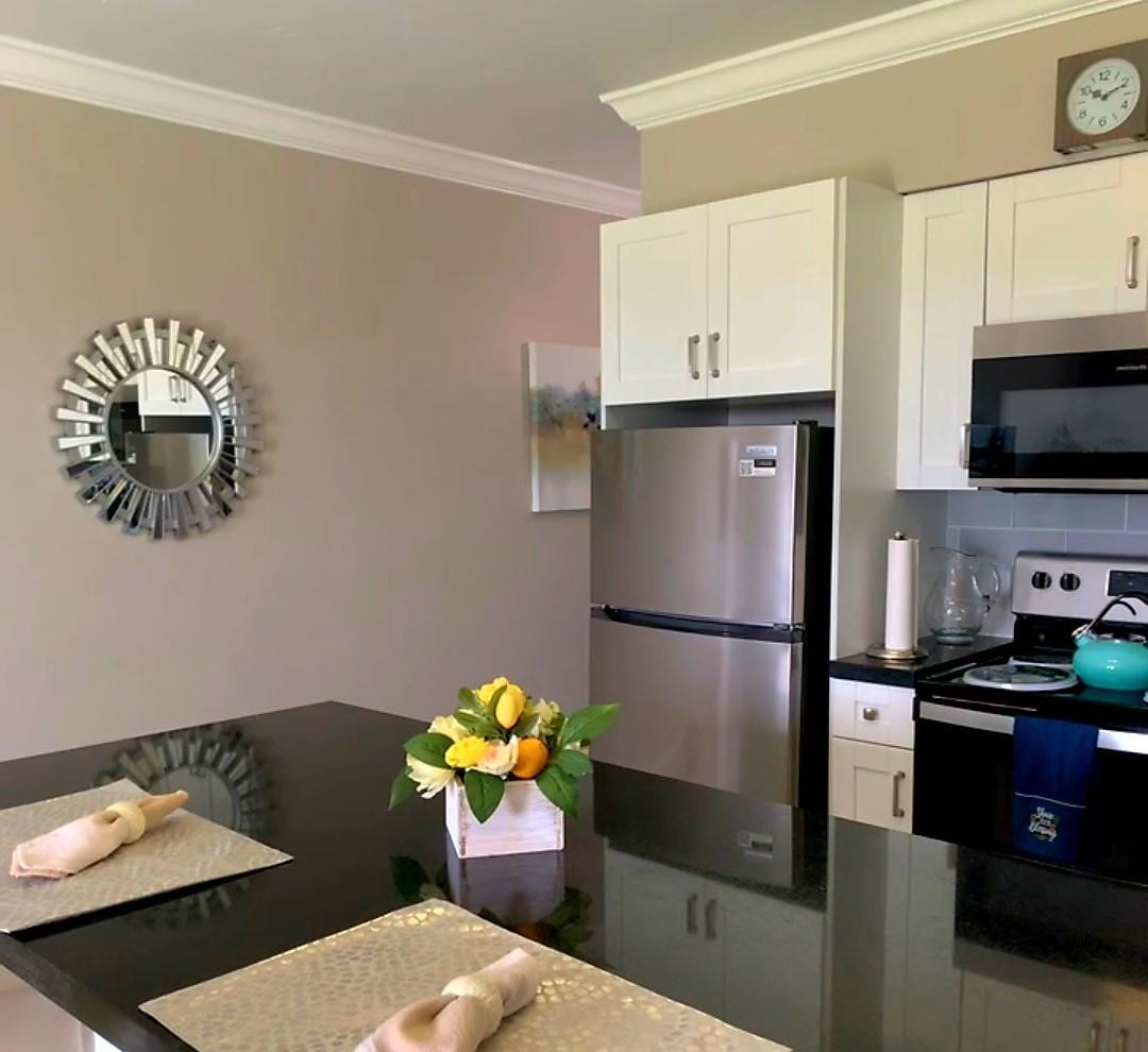 300 Duck Key Drive, Unit 6 Marathon, FL 33050 - Photo 10 of 32 a kitchen with stainless steel appliances granite countertop a refrigerator a stove a sink dishwasher and a microwave with wooden floor