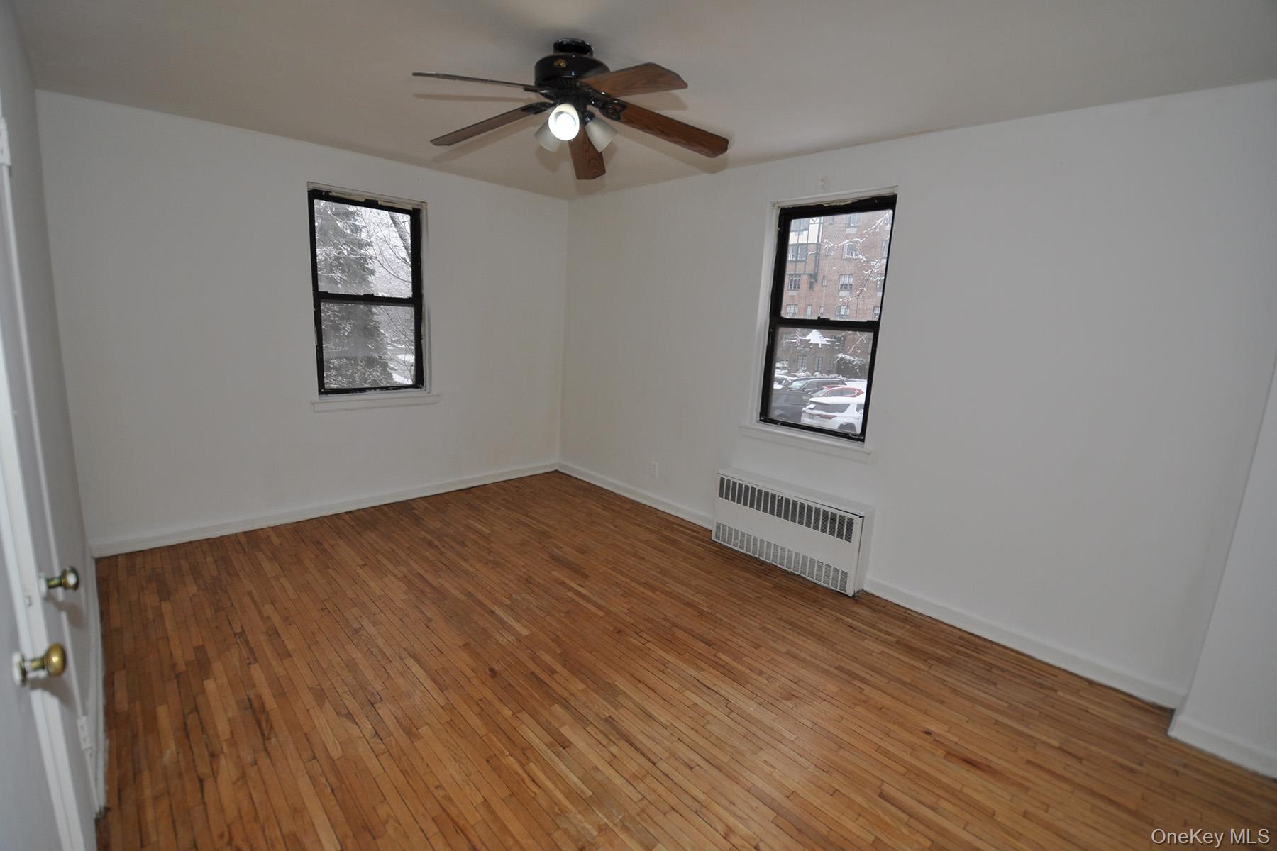 142 Garth Road, Unit 1R Scarsdale, NY 10583 - Photo 11 of 12 a view of empty room with wooden floor and fan