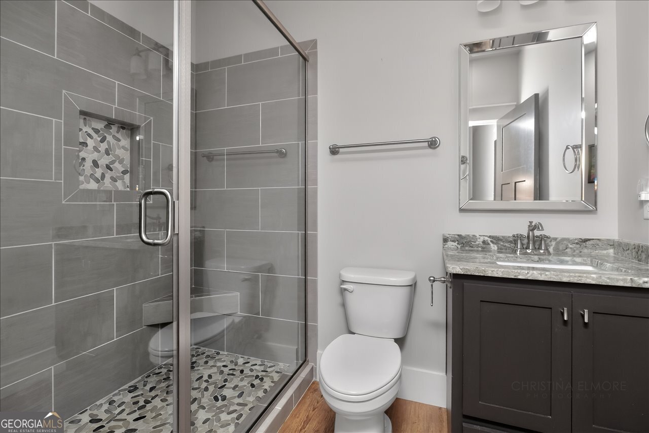 1031 Cherokee Road Perry, GA 31069 - Photo 72 of 104 a bathroom with a granite countertop toilet a sink a shower and a mirror
