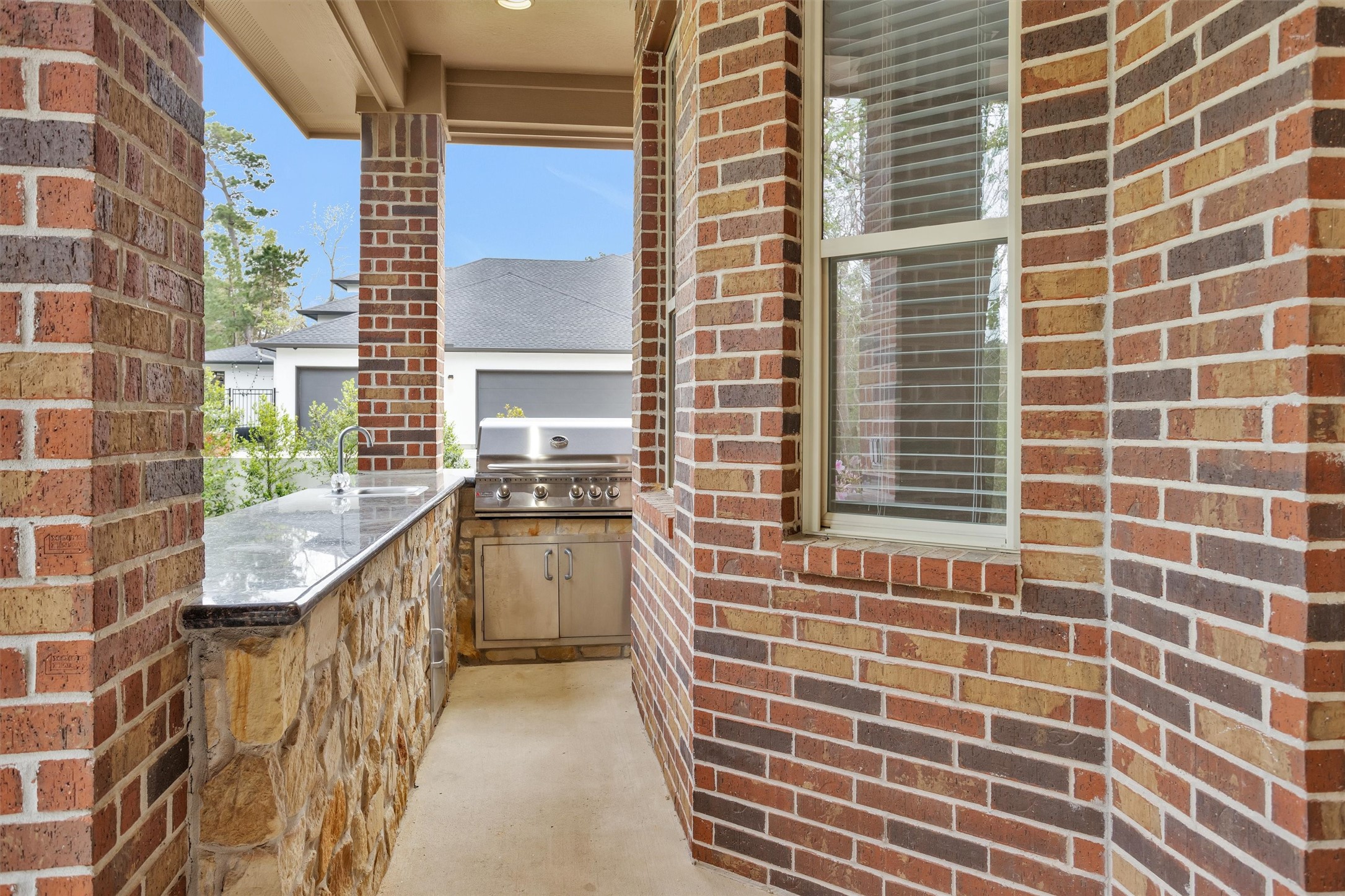 27910 Hansons Court Spring, TX 77386 - Photo 39 of 50 Outdoor kitchen with natural gas grill, sink, granite countertops, stone surround