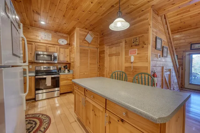 a open kitchen with a sink and dishwasher a stove with wooden floor