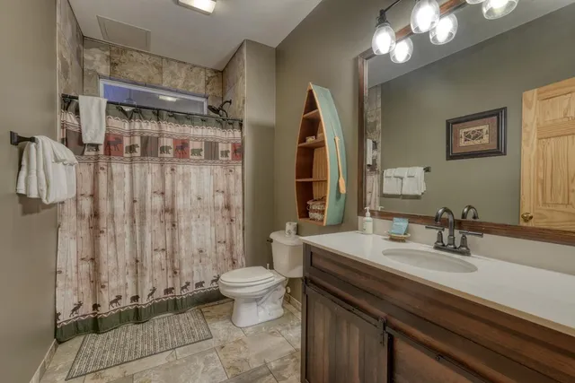 a bathroom with a double vanity sink toilet and shower