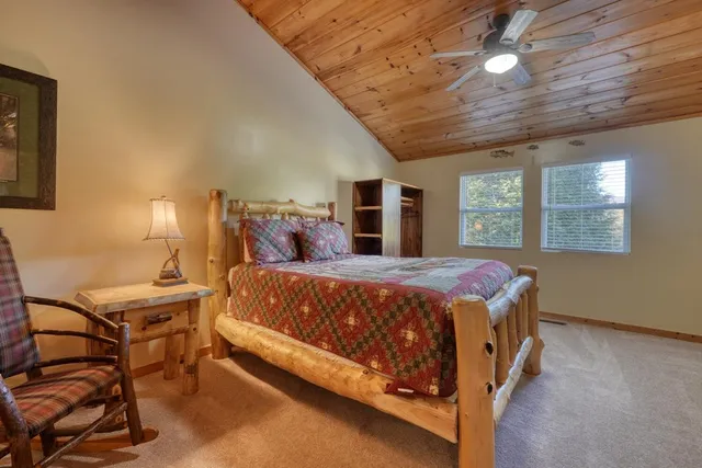a bed sitting in a spacious bedroom next to a window