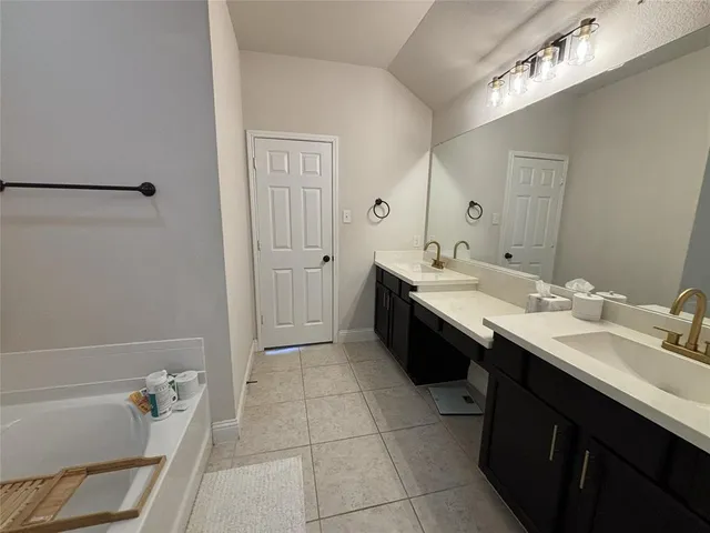 a bathroom with a tub sink and mirror