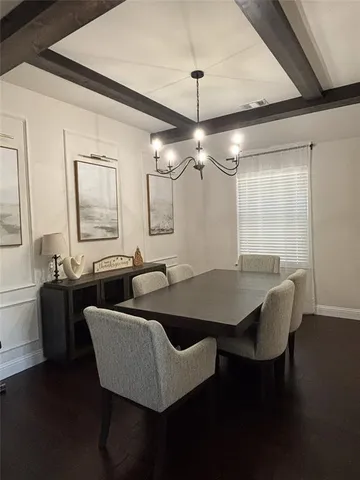 a view of a dining room with furniture a chandelier and wooden floor