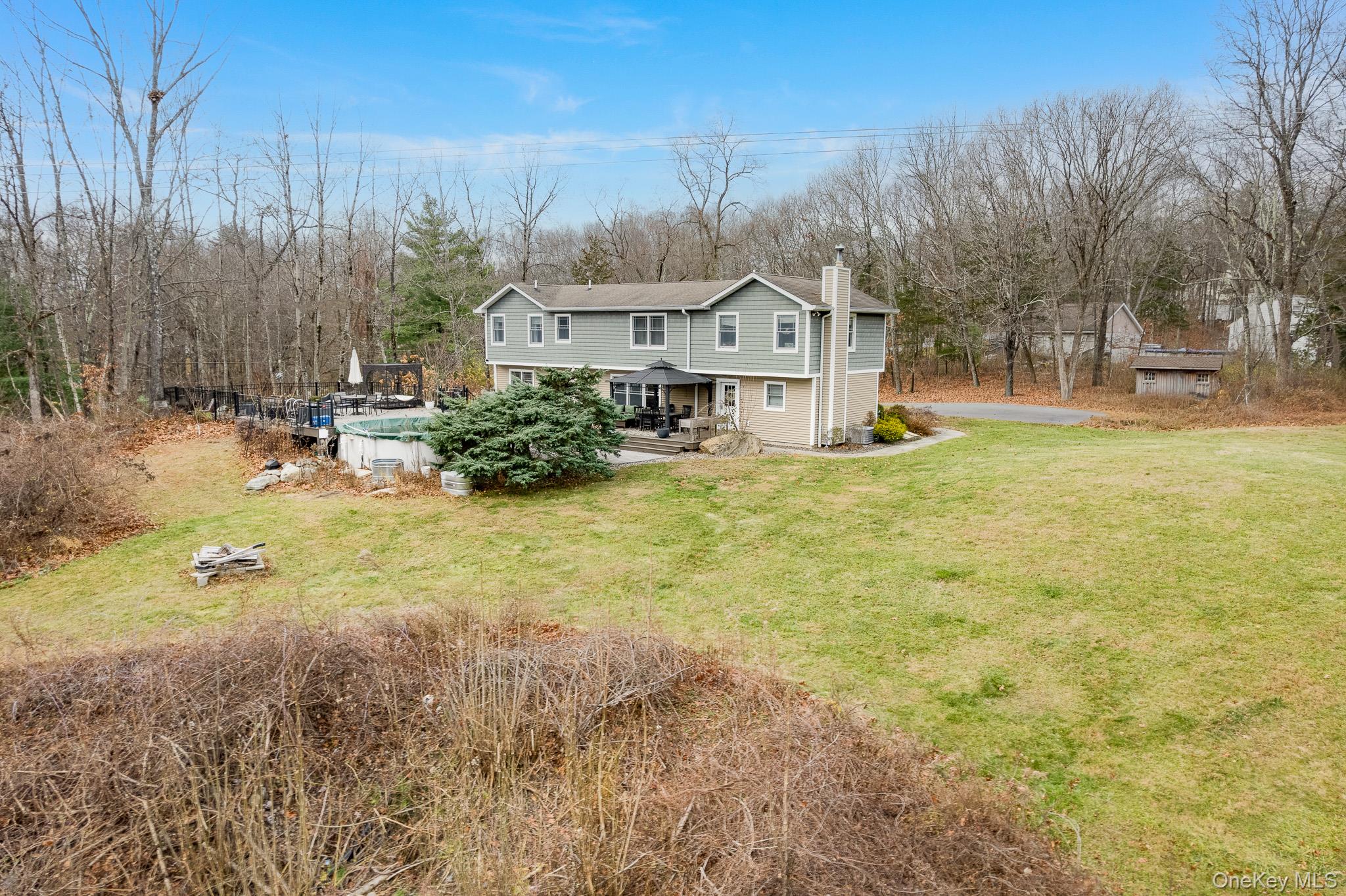 112 Pleasantview Road Pleasant Valley, NY 12569 - Photo 4 of 30 Rear view of house with an outdoor pool, a chimney, a lawn, and view of scattered trees