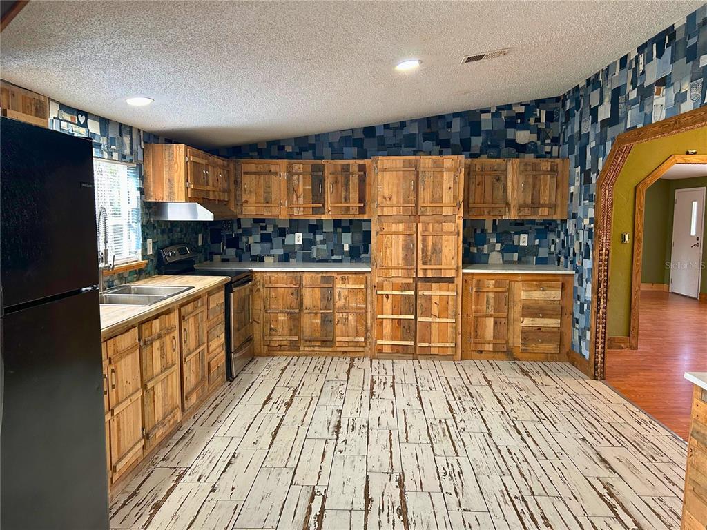 9867 Jerome Drive New Port Richey, FL 34654 - Photo 16 of 30 a kitchen with stainless steel appliances wooden floor a refrigerator and a stove top oven