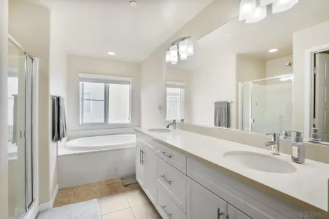a en suite bathroom with a double vanity sink and a mirror