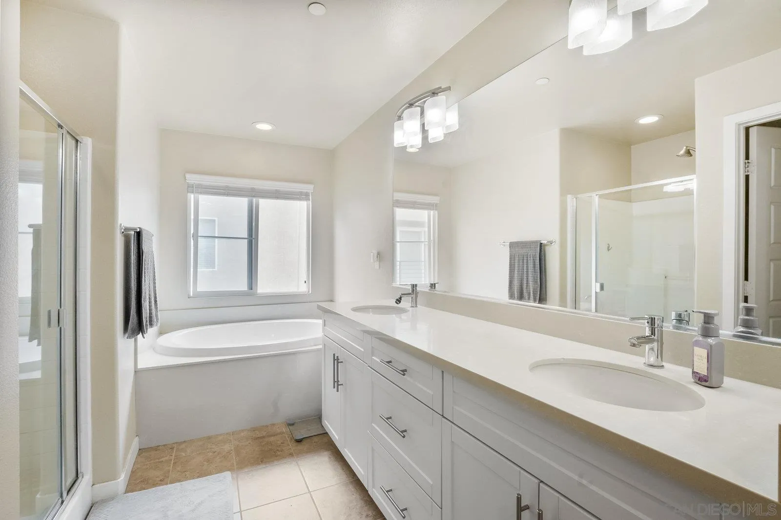 4541 Rainier Avenue, Unit 13 San Diego, CA 92120 - Photo 19 of 36 a bathroom with a sink double vanity mirror and a bathtub