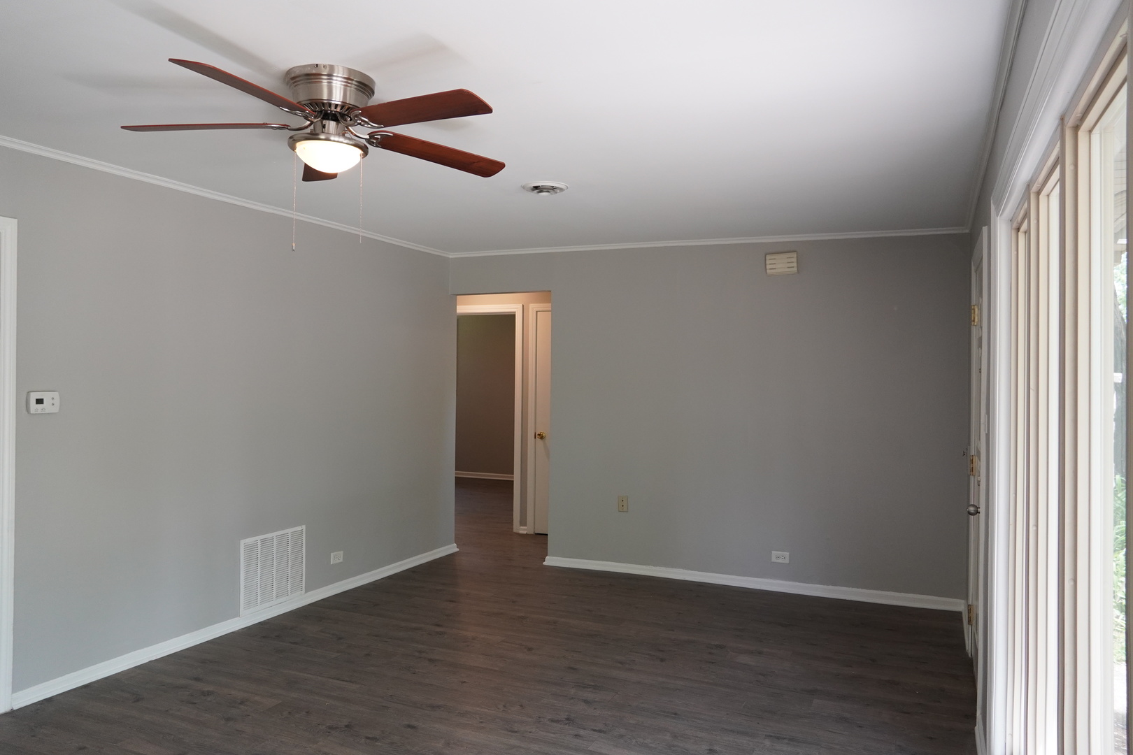 2460 Hawthorne Road Homewood, IL 60430 - Photo 4 of 11 an empty room with wooden floor fan and windows
