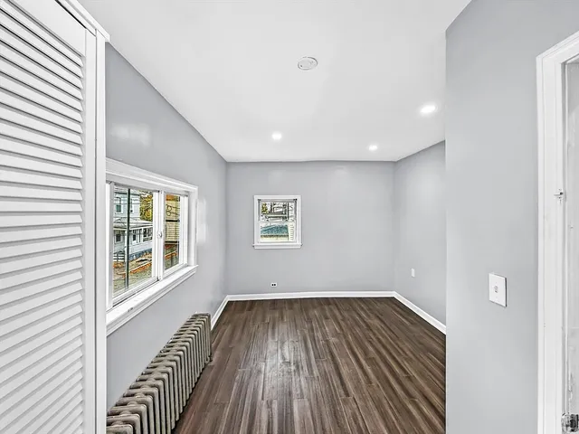 a view of a room with wooden floor and windows