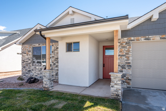 4978 North 75 East Enoch, UT 84721 - Photo 41 of 60 View of front of house with stone siding, roof with shingles, stucco siding, and a front yard