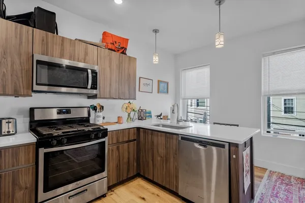 a kitchen with stainless steel appliances a stove sink microwave and cabinets