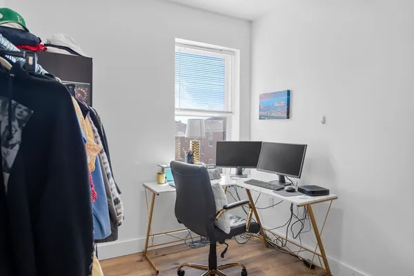 a view of a workspace with furniture and a window