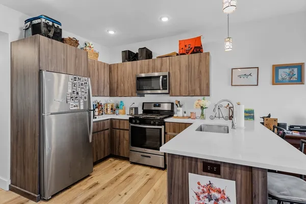 a kitchen with a refrigerator a stove a microwave a sink and cabinets