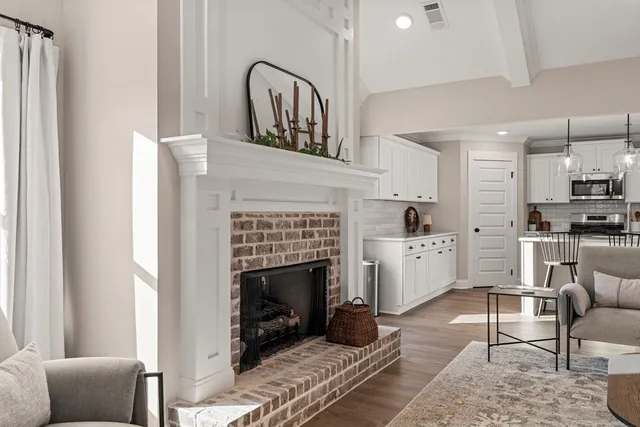 a living room with furniture a fireplace and kitchen view