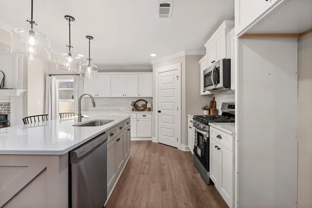 a kitchen with stainless steel appliances granite countertop a sink stove and refrigerator